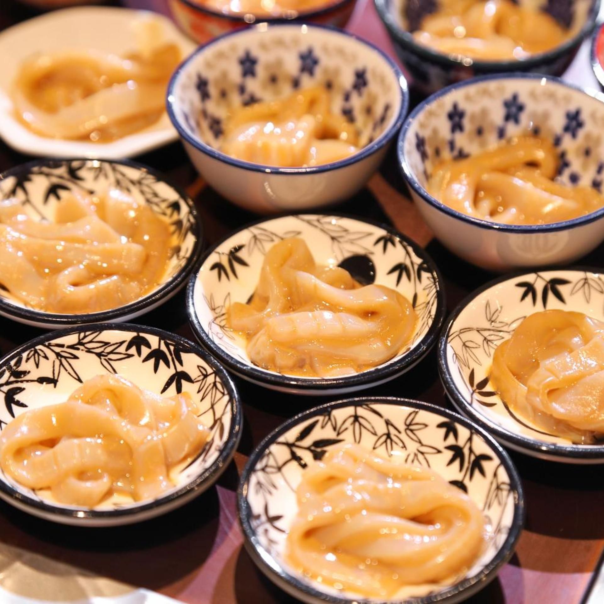 A collection of bowls with a creamy substance, possibly a dessert or condiment, arranged on a table.