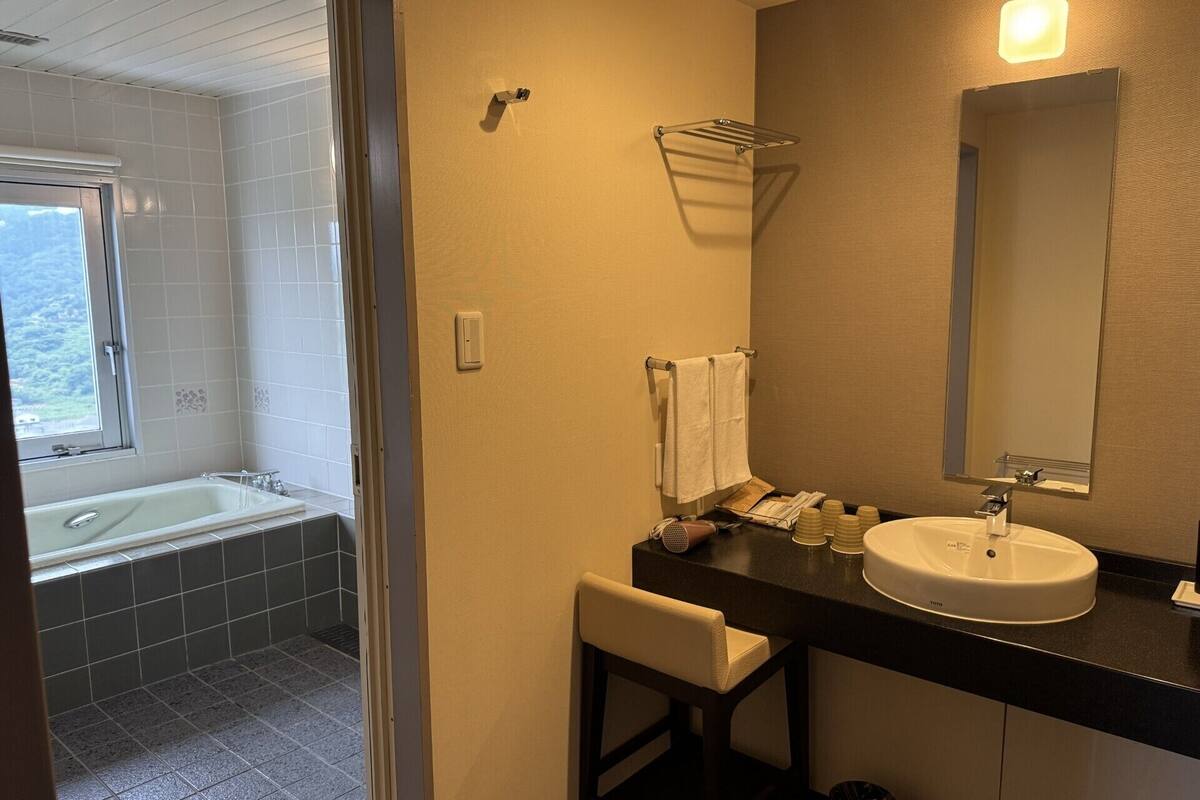 deluxe suite, 2 single beds, sea view | bathroom | combined shower/bathtub, deep-soaking bathtub, free toiletries