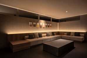 Una sala de estar moderna con un sofá modular, una mesa de centro e iluminación empotrada en la pared.