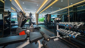 A gym with treadmills, a stationary bike, and a bench press. - Hotel Golden Dragon (Macau)