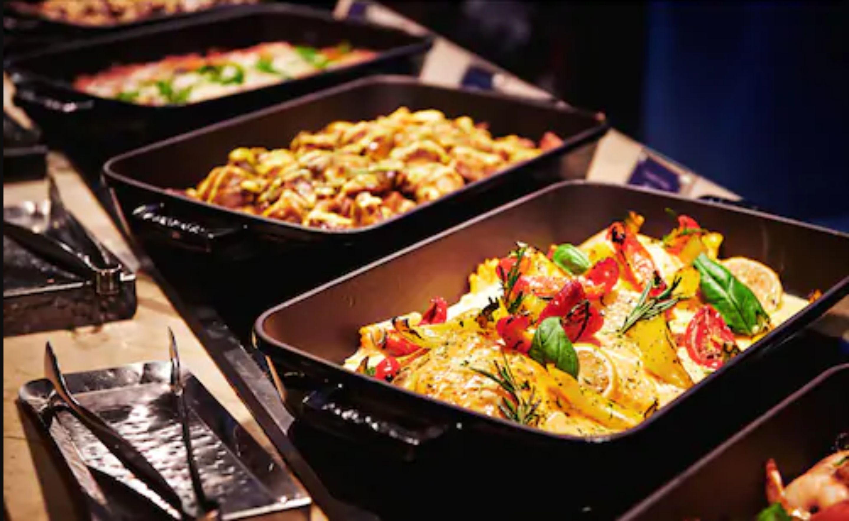 A buffet with various dishes, including a casserole with vegetables and herbs.