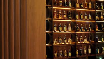A bar area with shelves of various liquor bottles.