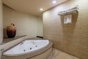 A modern bathroom with a freestanding bathtub, a large vase, and a towel rack.
