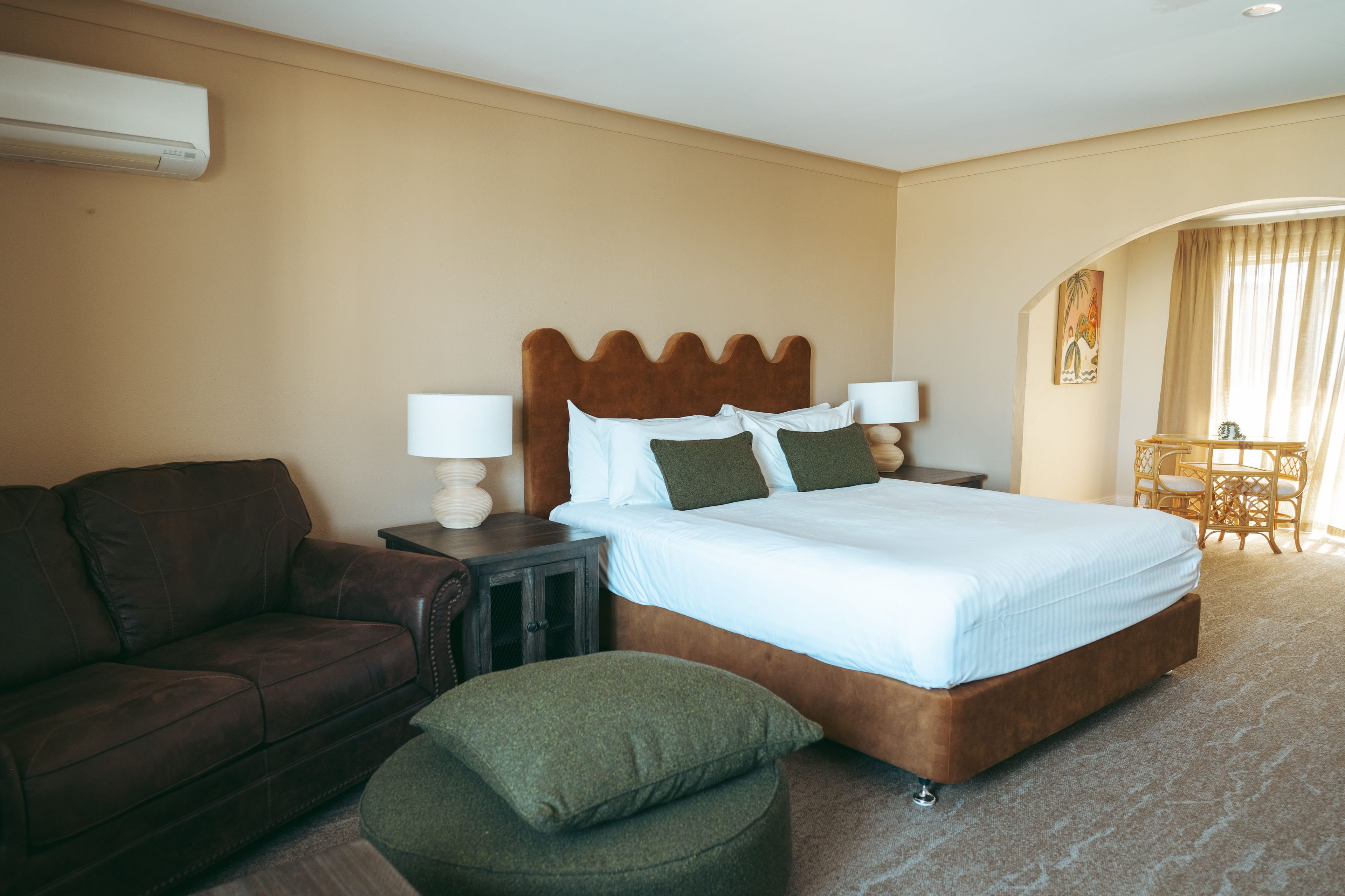 Una habitación de hotel con una cama, un sofá, una mesita y una silla.
