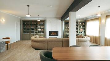 Una sala de estar moderna con chimenea, estanterías empotradas y un comedor.