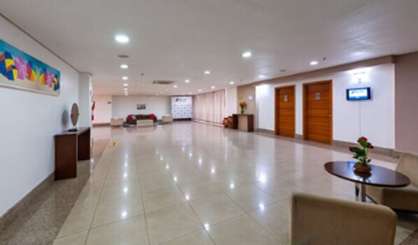 A spacious lobby with a reception desk, seating area, and a large wall with a colorful mural. - Blue Tree Premium Manaus (Manaus)