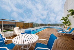 Una piscina al aire libre, sillones reclinables de piscina