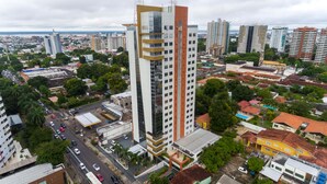 Ein Hochhaus mit mehreren Stockwerken, umgeben von einer Mischung aus Wohn- und Geschäftshäusern.