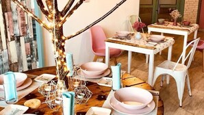 A dining area with a round wooden table set for four, surrounded by white chairs. - Hotel Villa de Benavente (Benavente)