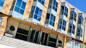 A modern hotel with a stone facade, large windows, and a prominent entrance. - Hotel Villa de Benavente (Benavente)
