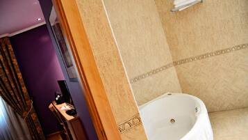Un baño con bañera, tocador con espejo y un perchero en la pared.