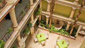 A multi-level atrium with balconies, green plants, and outdoor seating areas. - Hotel Villa Las Margaritas Plaza Cristal (Xalapa)