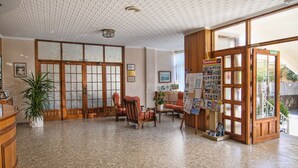 Een traditioneel Japans ingerichte receptie met tatami vloeren, een receptiebalie en een houten deur met de tekst 'SALIDA'.