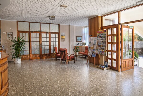 A traditional Japanese-style reception area with tatami flooring, a reception desk, and a wooden door labeled "SALIDA". - Hotel Vista Alegre (Benicassim)