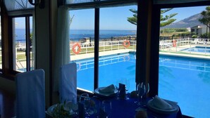 Comedor con vista a una piscina y al océano.