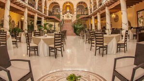 Ein geräumiger Innenhof mit hohen Decken, einer zentralen Treppe und mehreren Sitzbereichen.
