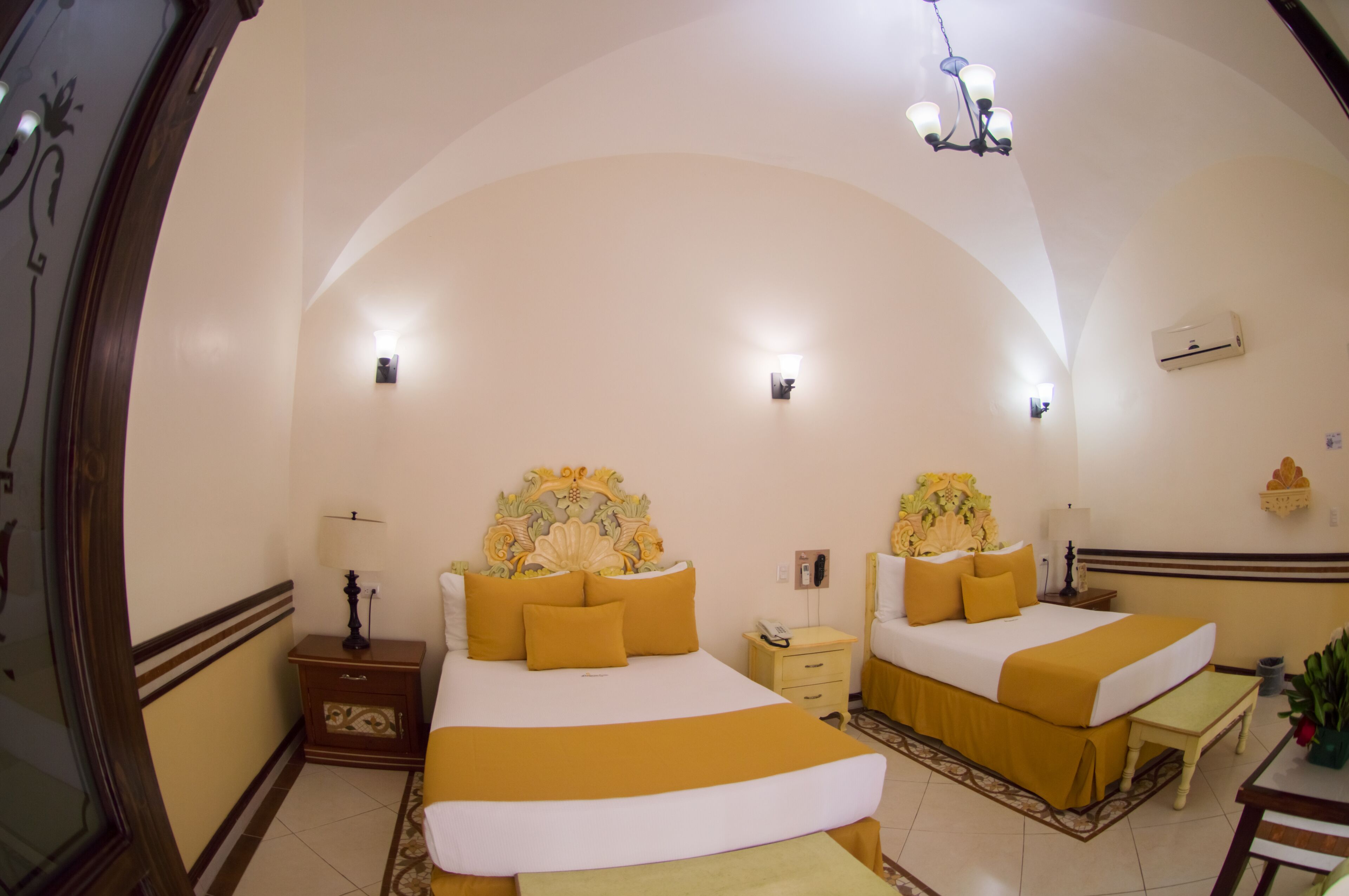 Una habitación con dos camas, una mesita de noche, una mesa y una silla.
