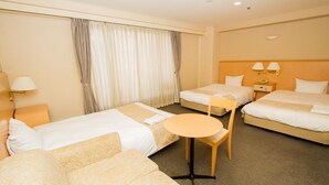 A hotel room with two single beds, a sofa, a round table, and a nightstand with a lamp. - Hotel Yokohama Camelot Japan (Yokohama)