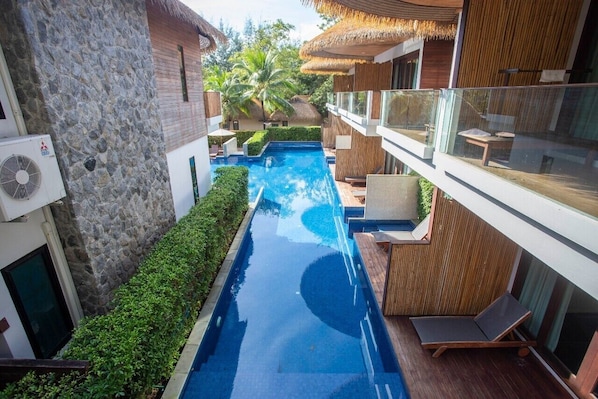 A modern hotel with a swimming pool, stone walls, and wooden balconies. - Tup Kaek Sunset Beach Resort (Krabi)