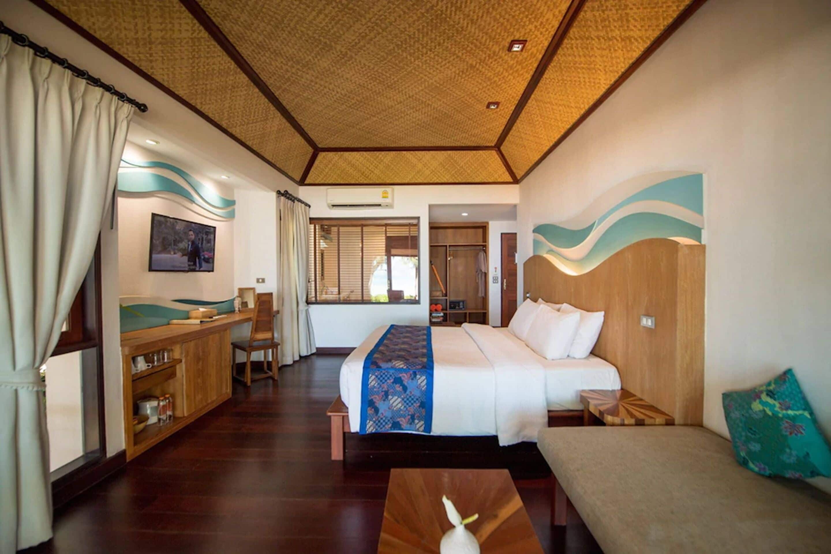 A hotel room with a bed, a desk, a chair, and a small table.