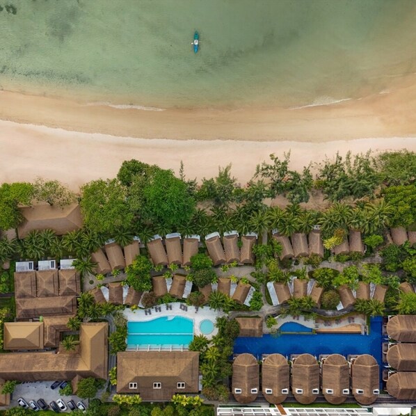 An aerial view of a resort with a beach, a swimming pool, and several bungalow-style accommodations. - Tup Kaek Sunset Beach Resort (Krabi)