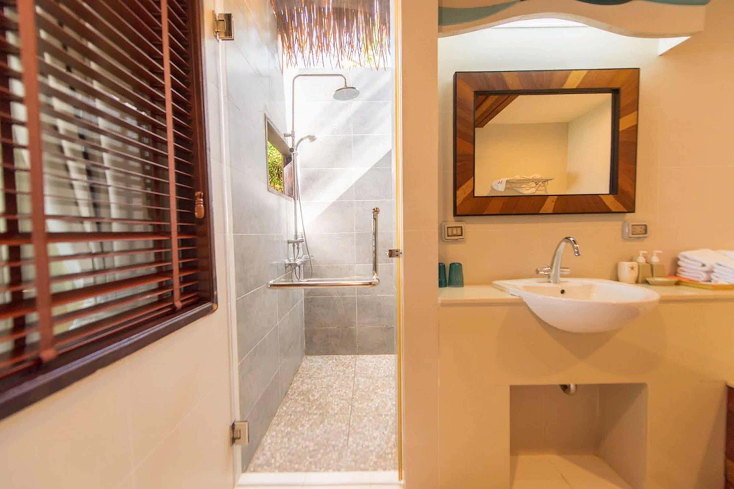 A bathroom with a shower, a sink, and a mirror.