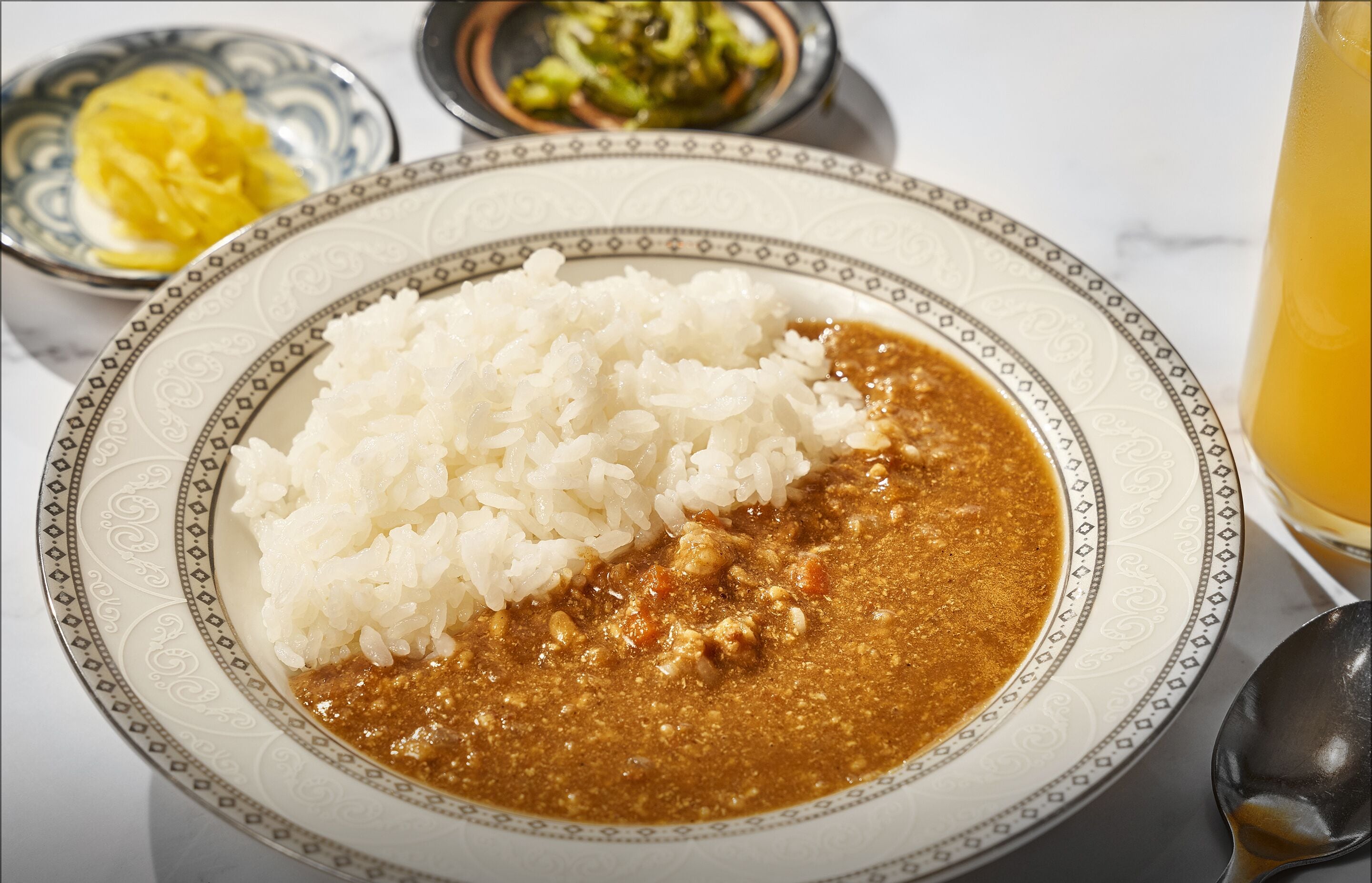 A plate of white rice and a brown sauce, possibly curry, on a decorative plate.