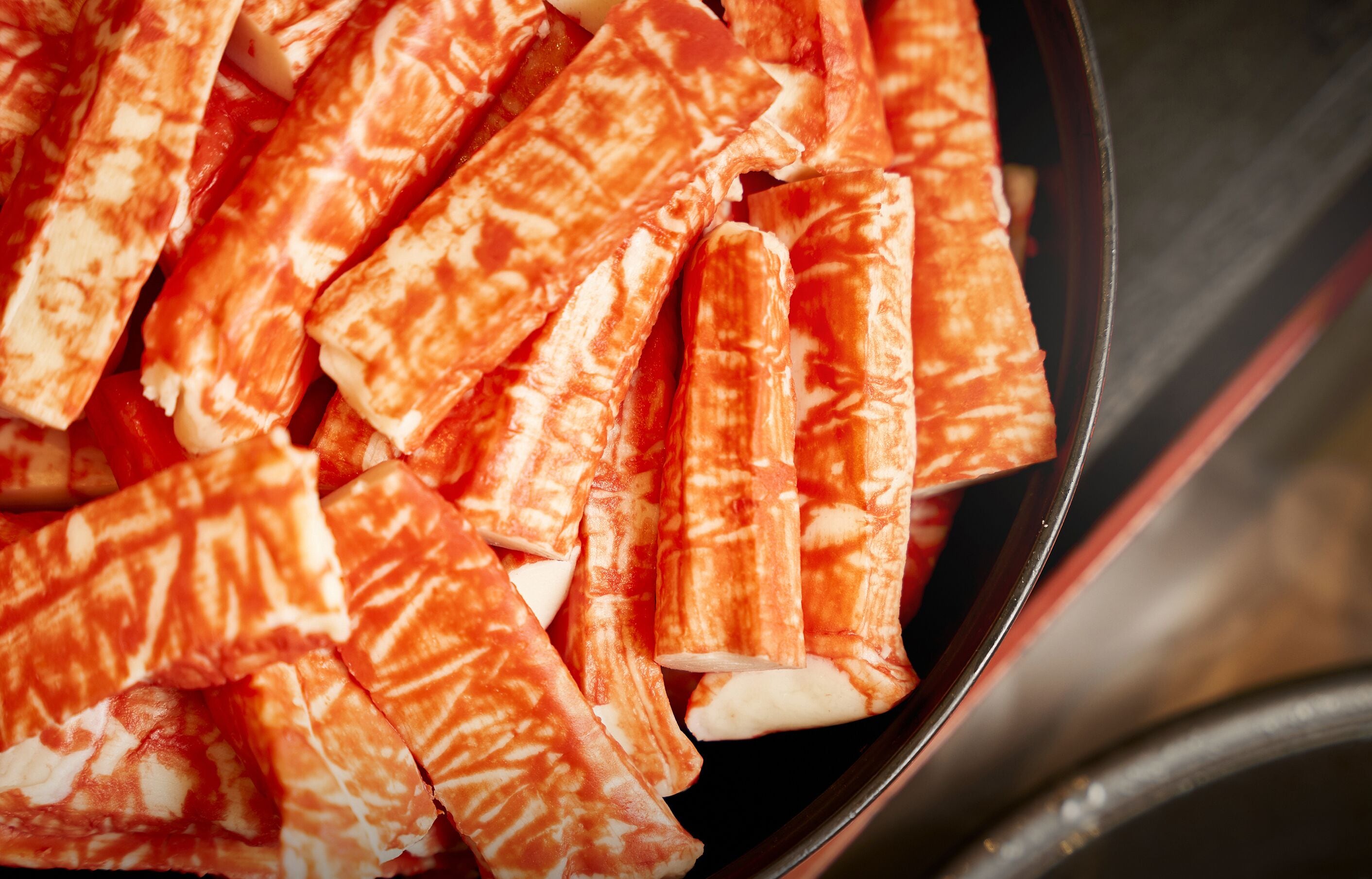 A close-up of several cylindrical objects with a patterned surface, likely a food item, in a container.