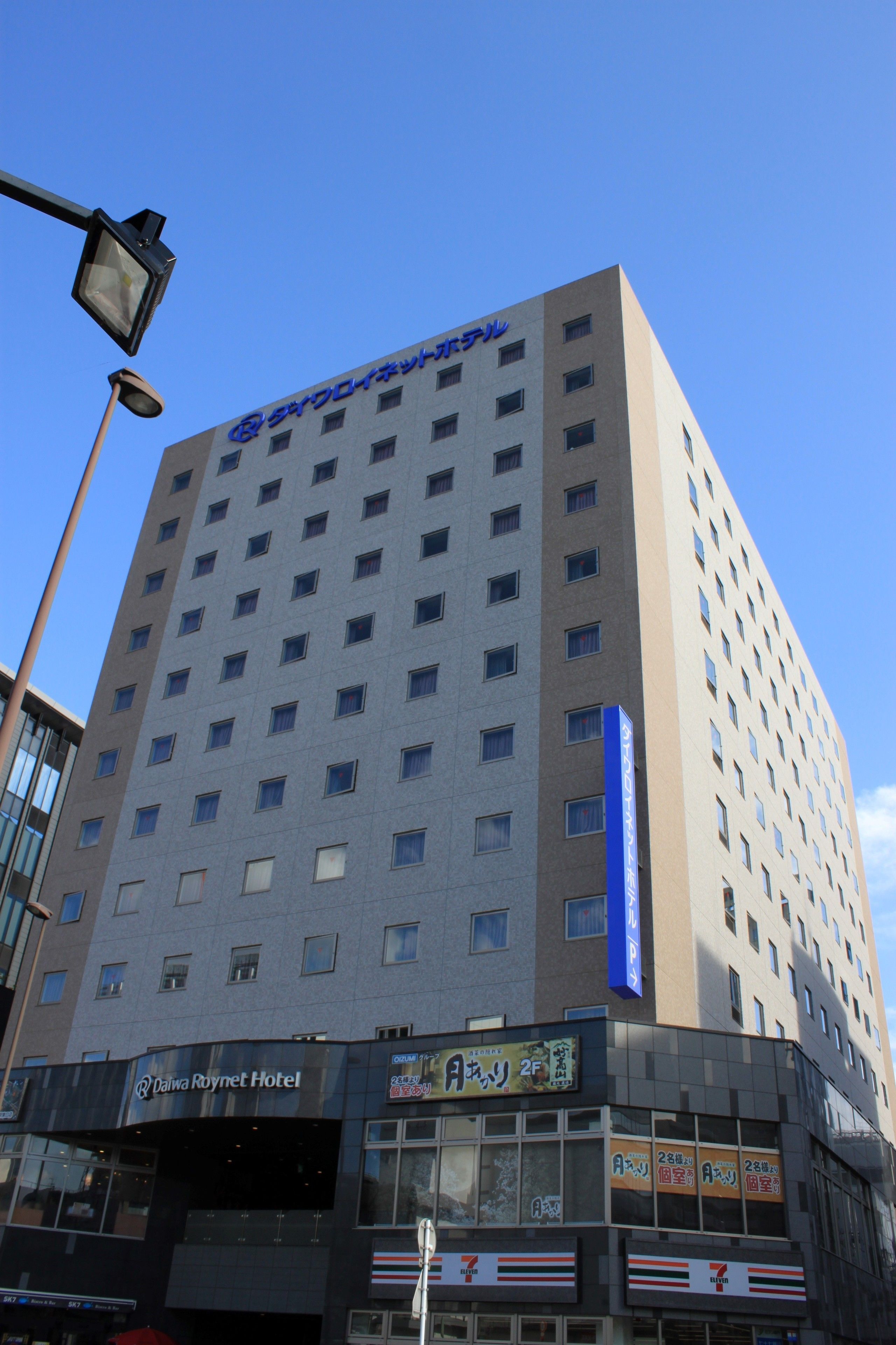 A tall hotel building with multiple floors and a clear blue sky in the background.