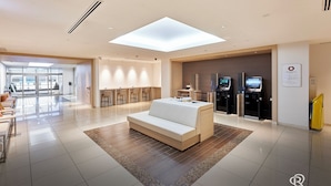 A modern hotel lobby with a reception desk, seating area, and self-service kiosks. - Daiwa Roynet Hotel Sendai (Sendai)