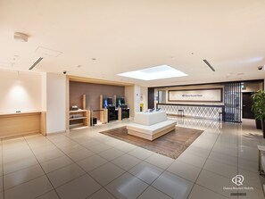 Welcome to our lobby, featuring a reception desk, comfortable seating area, and a large window with a view.
