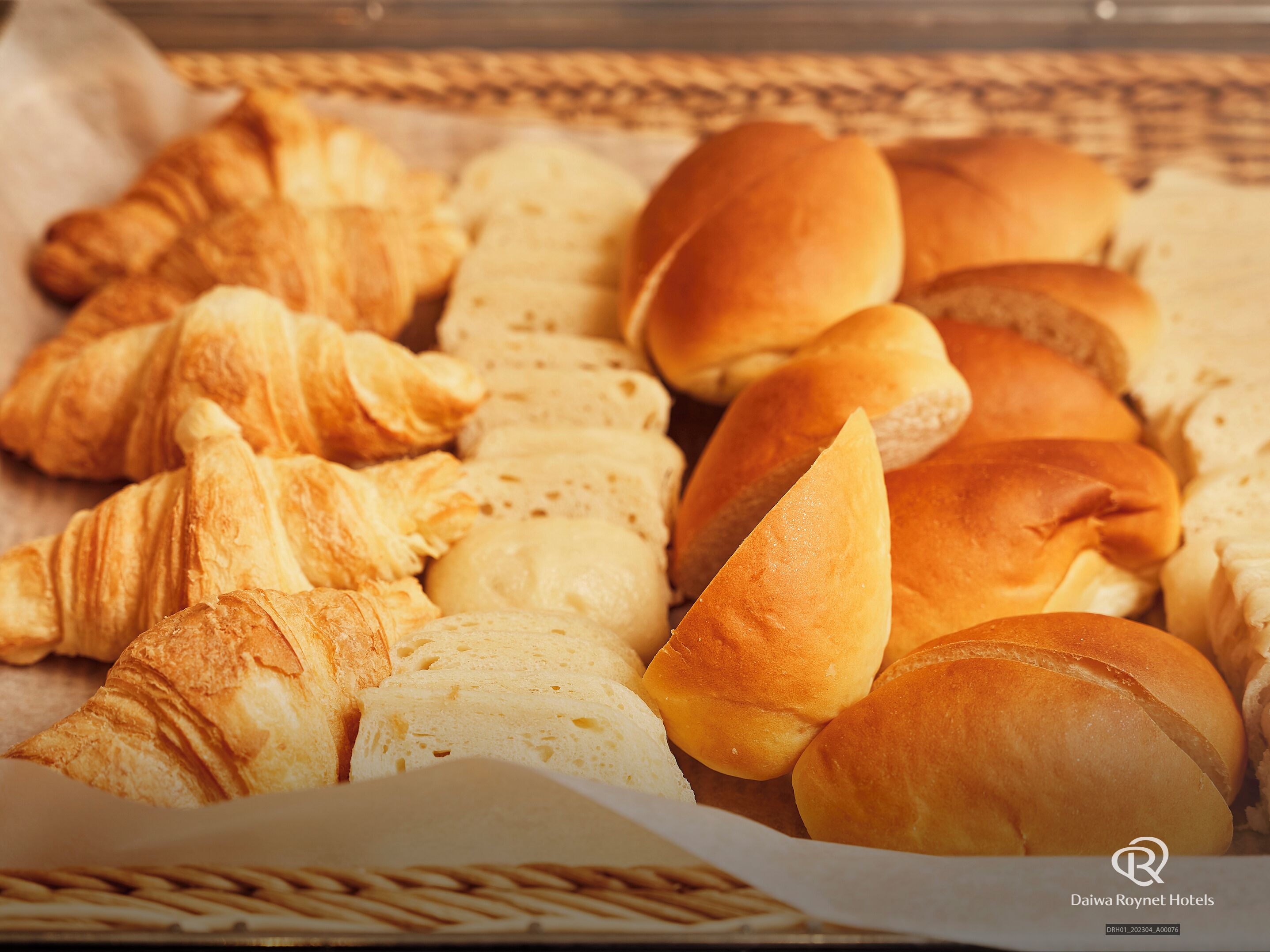 Variedad de productos de panadería, incluyendo croissants y bollos, dispuestos en una bandeja.