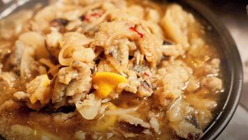 A close-up of a dish with various ingredients in a pan, possibly a stew or soup.