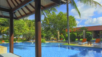 Una piscina al aire libre, sillones reclinables de piscina