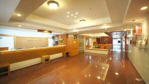 A spacious lobby with a reception desk, seating area, and a glass partition. - Yokohama Heiwa Plaza Hotel (Yokohama)