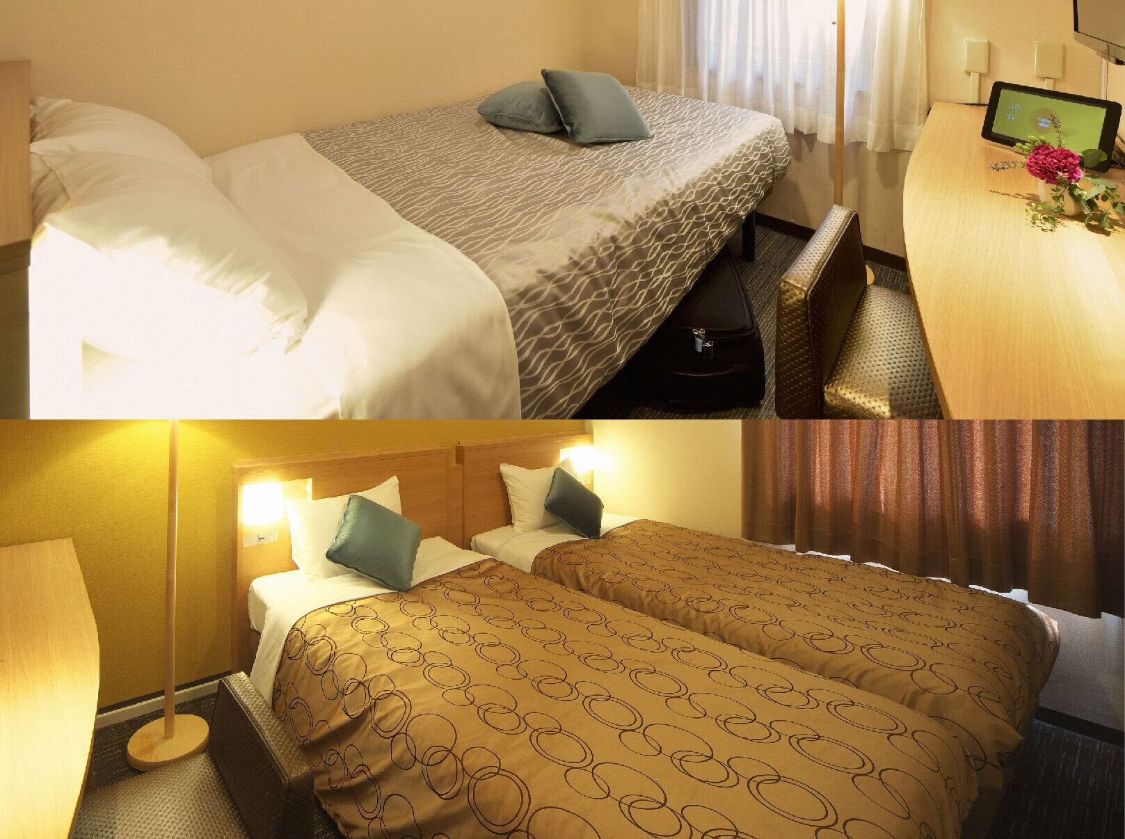 A hotel room with a bed, bedside table, and a desk with a monitor.