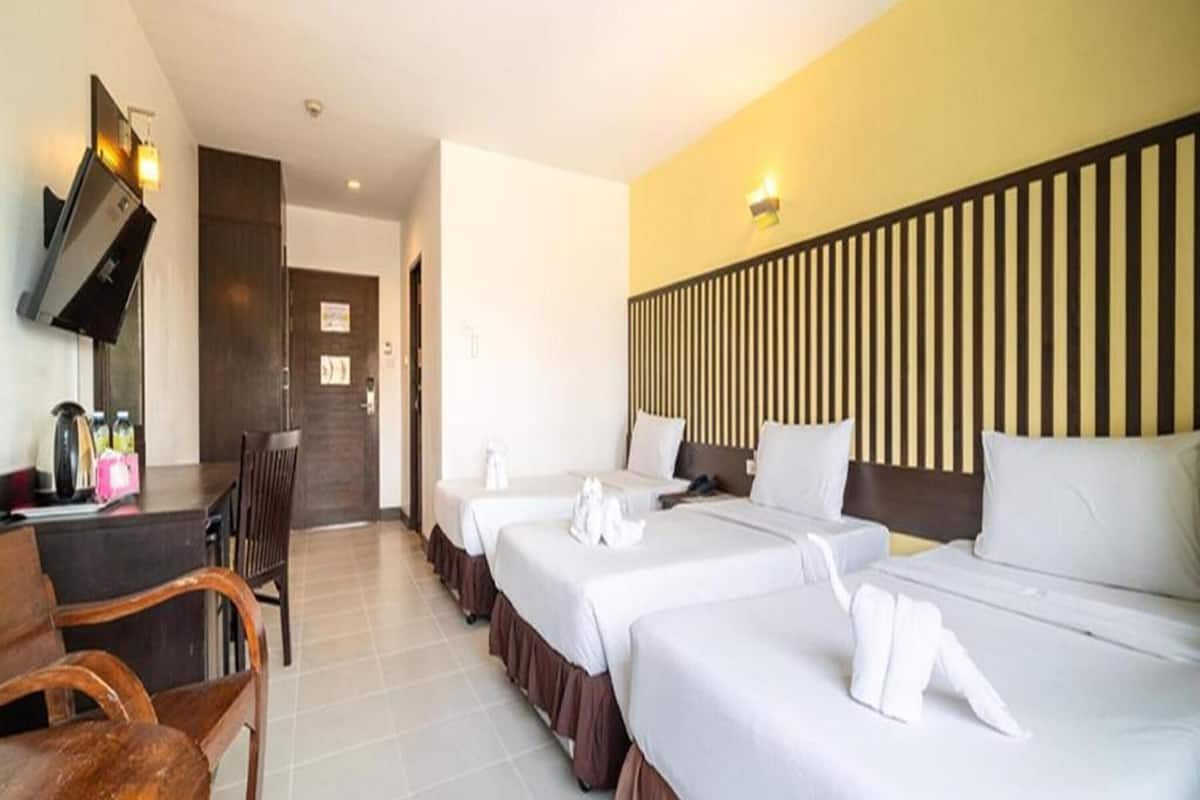 Een hotelkamer met twee bedden, een bureau en een stoel.
