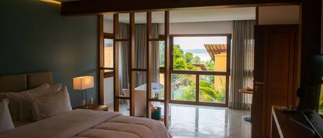 Una habitación de hotel con una cama grande, baño, vistas al exterior y televisión.