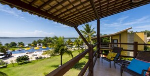 Un balcón con vista a una piscina y una playa.