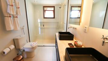 Une salle de bain moderne avec une douche à parois de verre, un lavabo noir et des toilettes.