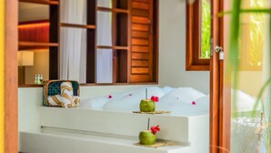 A bathroom with a bathtub, wooden shelves, and a mirror. - Pipa Lagoa Hotel (Tibau do Sul)