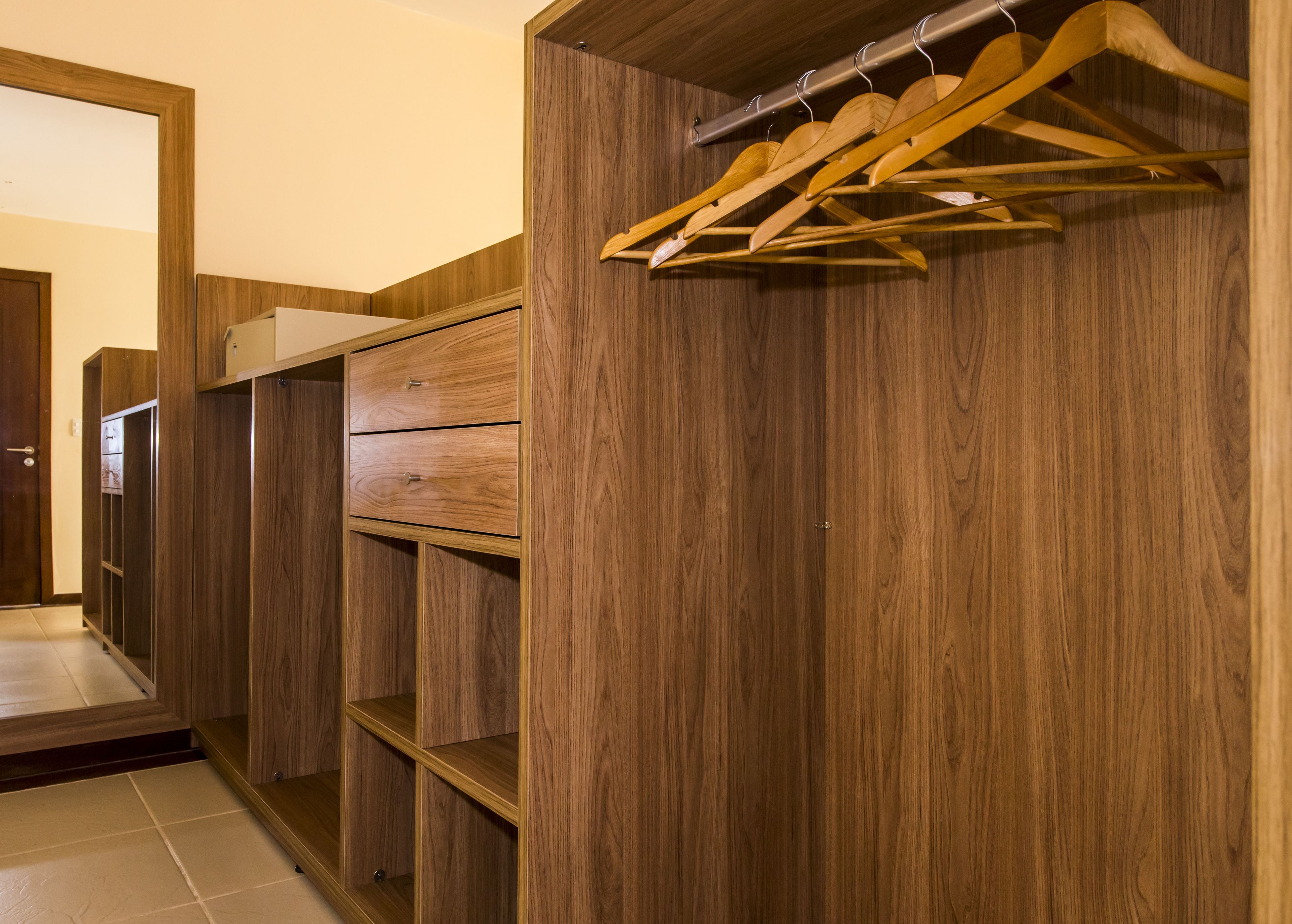 Ein Holzschrank mit mehreren Regalen und einer Kleiderstange.
