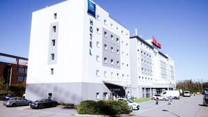 A modern hotel with a white facade, multiple floors, and a prominent "Ibis Budget" sign. - ibis budget Luxembourg Aéroport (Niederanven)