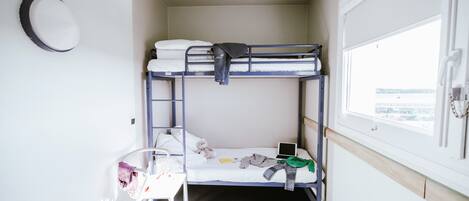 Une chambre avec un lit superposé, un bureau, une chaise et une fenêtre donnant sur un beau paysage.