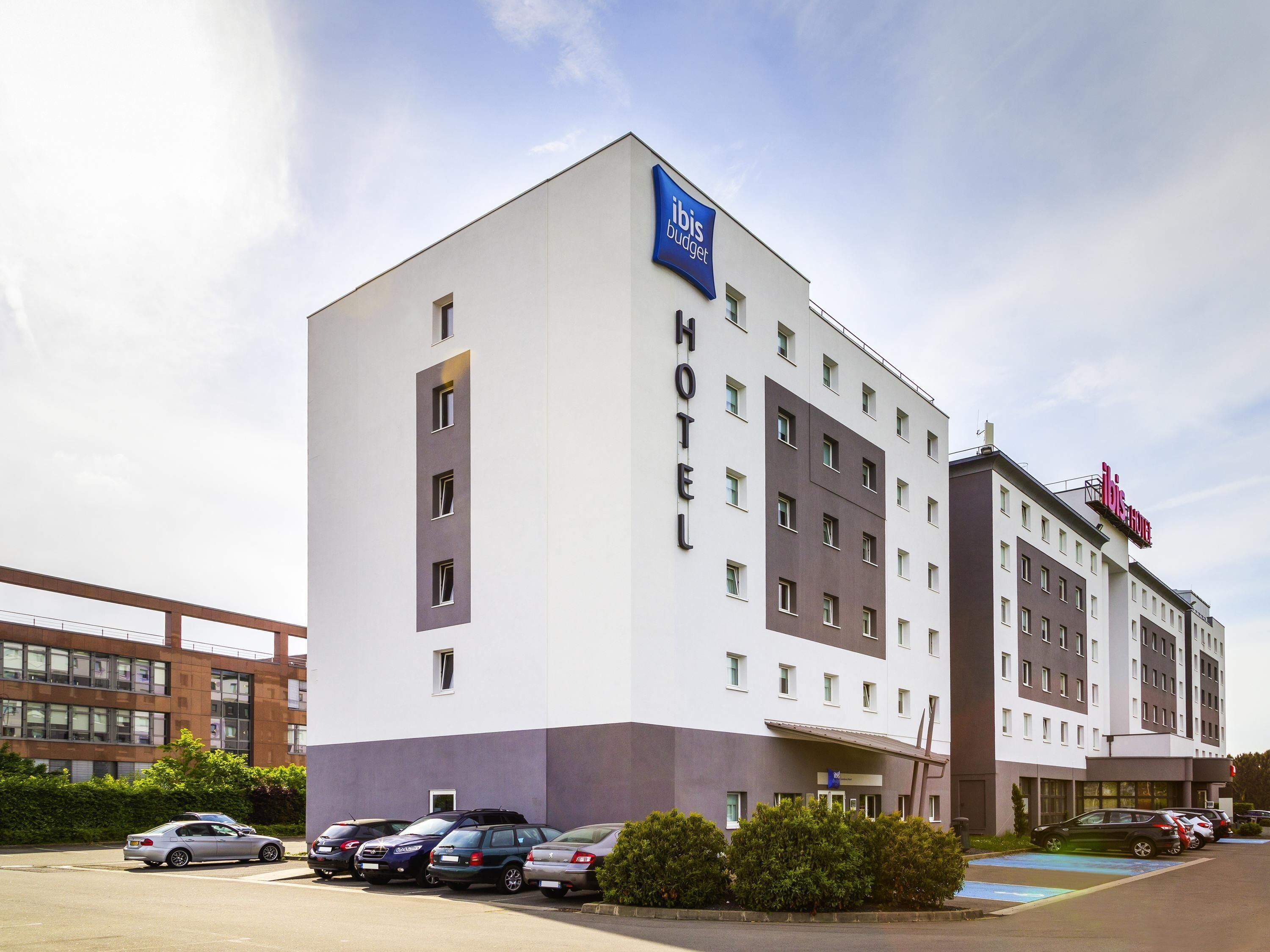 Een hotel met een modern design, met een opvallend bord voor ibis budget.