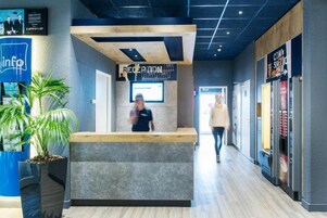 A reception area with a reception desk, a digital screen, and a sign that reads "RECEPTION."