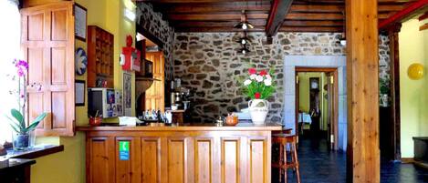 Una cocina rústica con armarios de madera, una pared de piedra y una barra de madera.