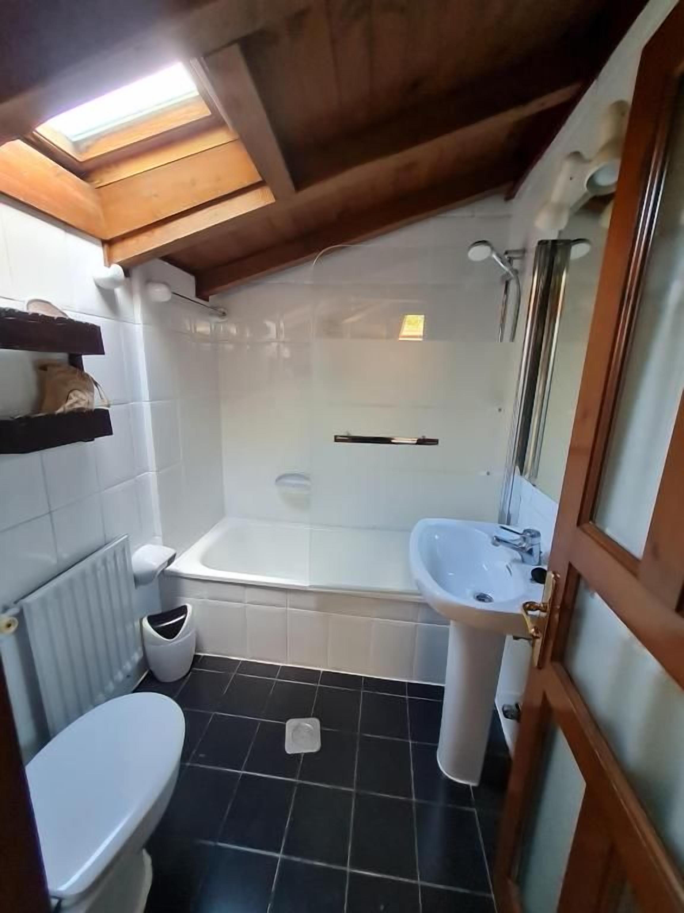 Un baño pequeño con inodoro, lavamanos y bañera.