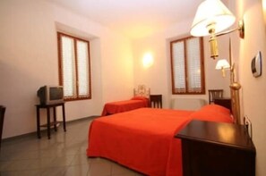 A hotel room with two beds, a television on a small table, and a lamp on the wall. - La Notte Blu (Florence)