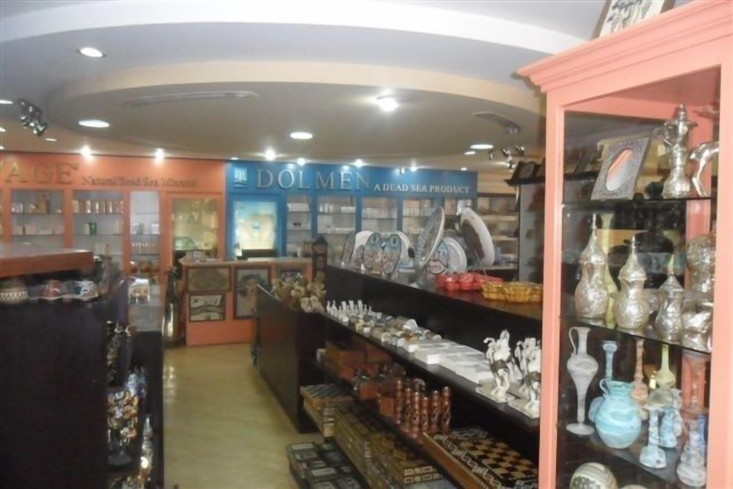 L'intérieur d'un magasin, avec des étagères remplies de verrerie et d'objets décoratifs.